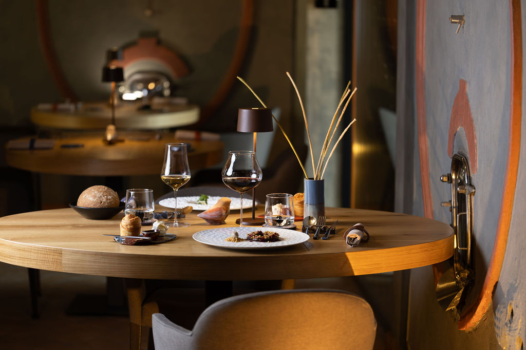 Tavolo elegante di PS Ristorante con piatto gourmet e calici di vino